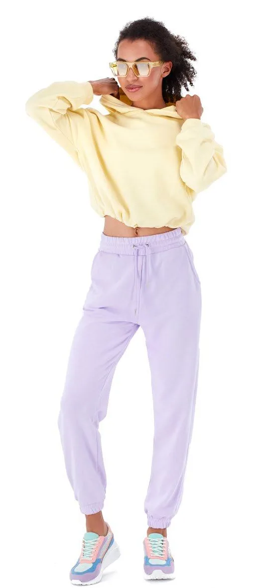 Model wearing a yellow hoodie and lilac joggers, shot in Fashion Studio